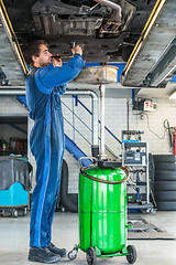 Image showing Mechanic Repairing Car On Hydraulic Lift In Automobile Shop
