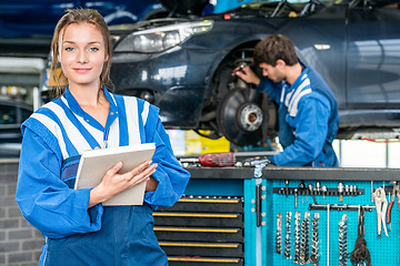 Image showing Confident Female Mechanic With Maintenance Checklist At Garage