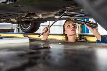 Image showing Mechanic With Flashlight Repairing Car On Hydraulic Lift