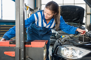 Image showing Female Mechanic Aligning Headlights