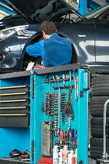 Image showing Tool Cart With Male Mechanic Repairing Car