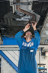 Image showing Male Mechanic Examining Exhaust System Of Car