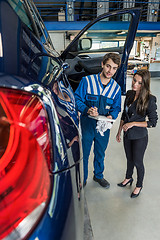 Image showing Car Mechanic Preparing Checklist While Standing With Customer