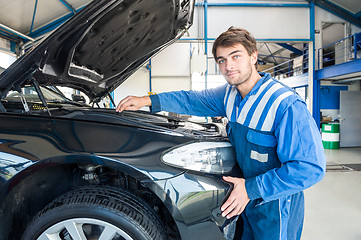 Image showing Mechanic Repairing Car Engine In Garage