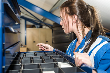 Image showing Female Mechanic Selecting Screw From Drawer At Garage