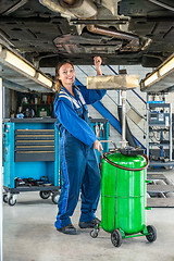 Image showing Female Mechanic Repairing Car On Hydraulic Lift In Garage