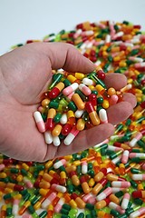 Image showing Hands full of medication pill capsules