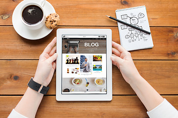 Image showing close up of woman with tablet pc on wooden table