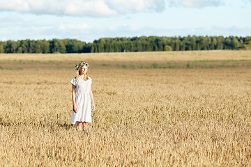 Image showing happy young woman in flower wreath on cereal field