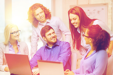 Image showing smiling team with laptop computers in office