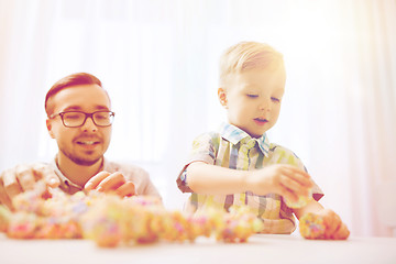 Image showing father and son playing with ball clay at home