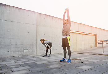 Image showing tired couple stretching after exercise