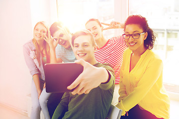 Image showing smiling students making picture with tablet pc