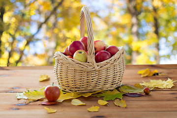 Image showing close up of basket with apples on wooden table