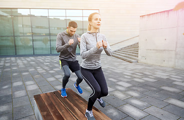 Image showing couple making step exercise on city street bench