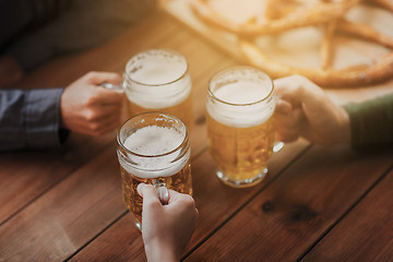 Image showing close up of hands with beer mugs at bar or pub