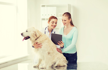 Image showing happy woman with dog and doctor at vet clinic