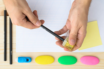 Image showing Top view of man\'s hands sharpening pencil