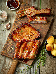 Image showing grilled ribs on wooden cutting board