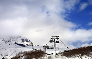 Image showing Chair lift on ski resort and snow mountain in clouds