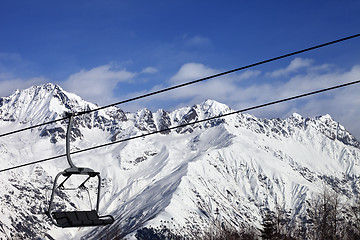 Image showing Chair-lift in snow winter mountains at nice sunny day