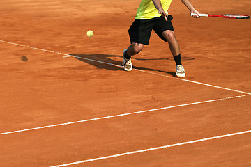 Image showing Male tennis player in action on the court on a sunny day