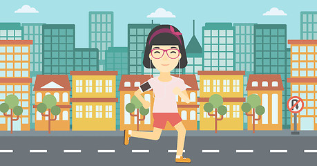 Image showing Woman running with earphones and smartphone.