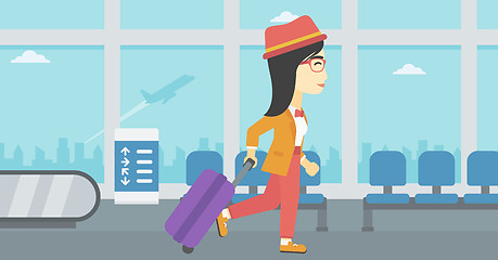 Image showing Woman walking with suitcase at the airport.