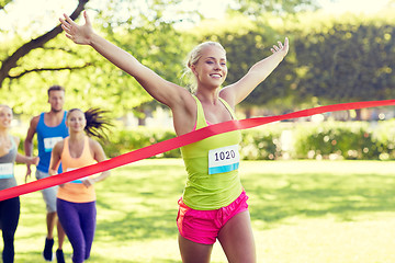 Image showing happy young female runner winning on race finish