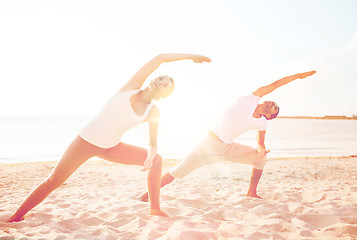 Image showing couple making yoga exercises outdoors