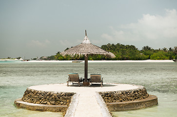 Image showing palapa and sunbeds by sea on maldives beach