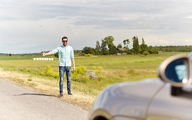 Image showing man hitchhiking and stopping car at countryside