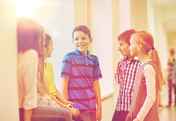 Image showing group of smiling school kids talking in corridor