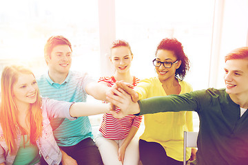 Image showing smiling students making high five gesture sitting