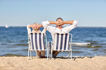 Image showing senior couple sitting on chairs at summer beach