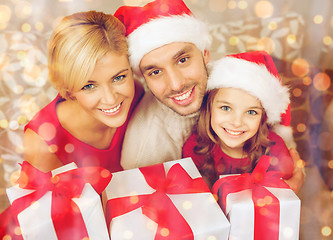 Image showing smiling family holding many gift boxes