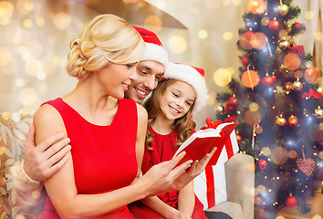 Image showing smiling family reading book