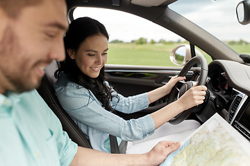 Image showing happy man and woman with road map driving in car