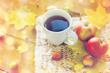 Image showing close up of tea cup on table with autumn leaves