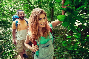 Image showing happy couple with backpacks hiking in woods