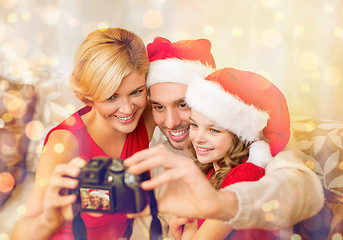 Image showing smiling family in santa helper hats taking picture