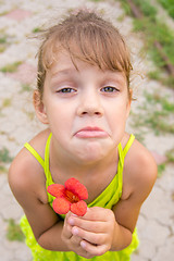 Image showing Funny girl with a flower in her hand crouched begging a face looking to the frame