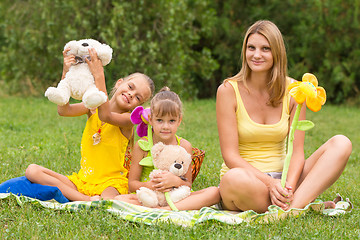 Image showing Mother and daughter sitting with soft toys on a picnic