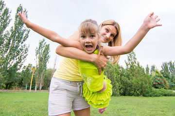 Image showing Mom keeps daughter in her arms and rocking