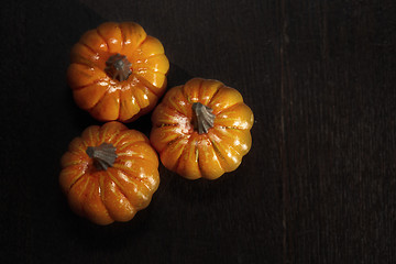 Image showing Three pumpkins on a wooden table