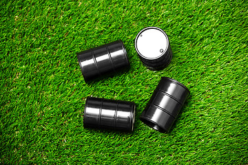 Image showing High angle view on four oil barrels on a grass