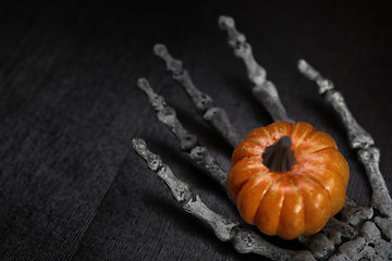 Image showing Skeleton hand holding pumpkin