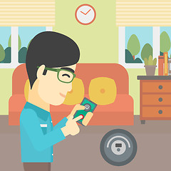 Image showing Man controlling vacuum cleaner with smartphone.