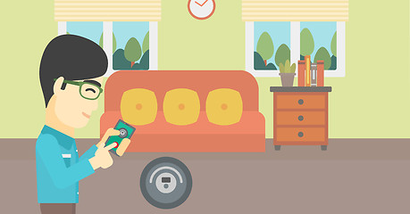 Image showing Man controlling vacuum cleaner with smartphone.