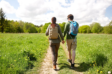 Image showing happy couple with backpacks hiking outdoors